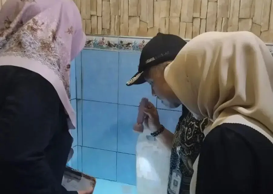 Plt Lurah Pancoran Mas, Denny Ferdian bersama Ketua TP-PKK Panmas Rusminah monitoring PSN di bak mandi warga, belum lama ini. (Foto: dok. Narasumber)