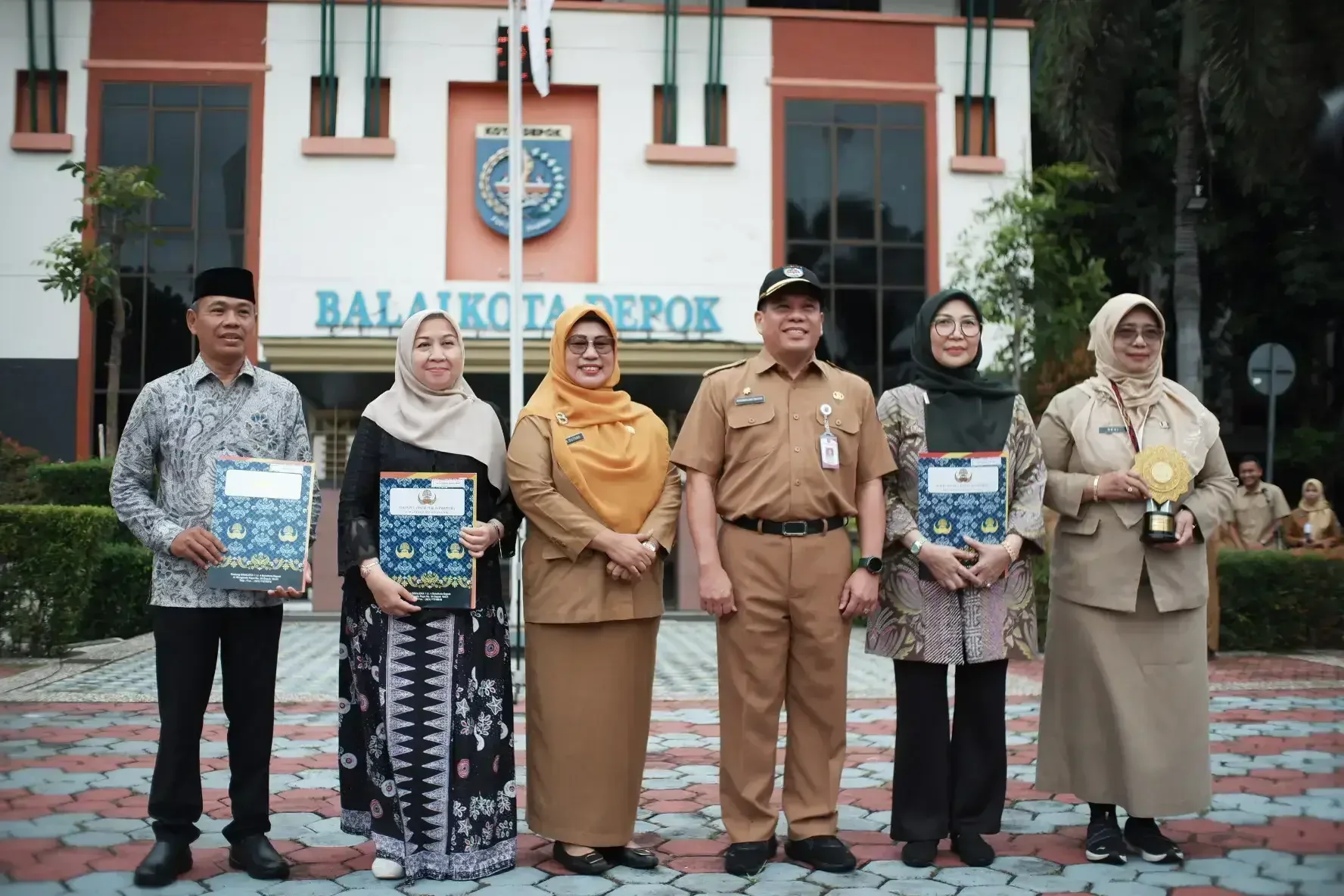 Sekda Kota Depok Mangguluang Mansur saat menyerahkan penghargaan UHC Award tingkat nasional kepada Kepala Dinkes Kota Depok Devi Maryori, Senin (02/02/26). (Foto: JD 01/Diskominfo)
