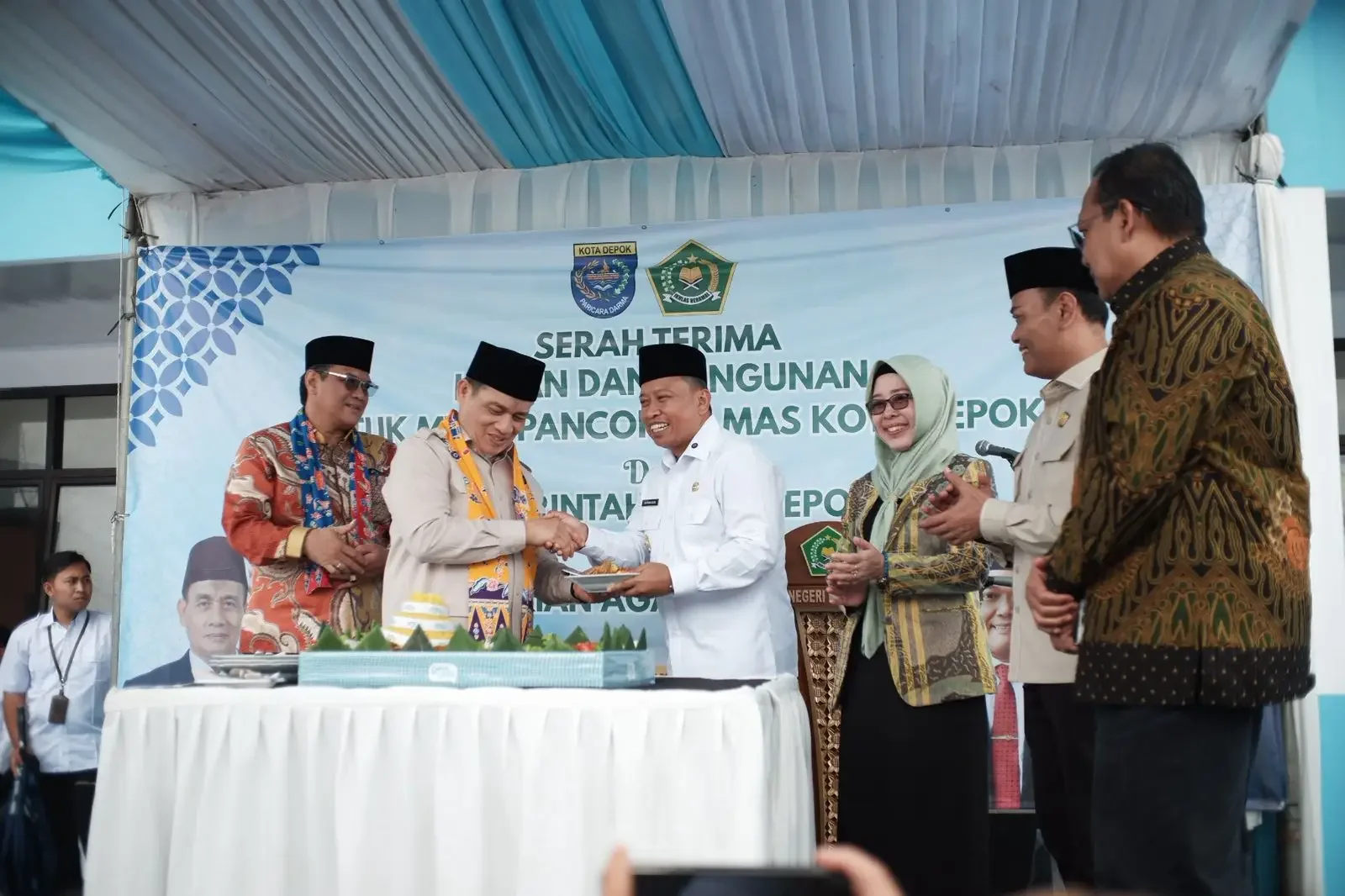 Wali Kota Depok, Supian Suri menyerahkan potongan nasi tumpeng kepada Wakil Menteri Agama RI Romo Muhammad Syaf'i saat peresmian Gedung MTs Negeri Pancoran Mas, Rabu (21/01/26). (Foto: JD 01/Diskominfo Depok)