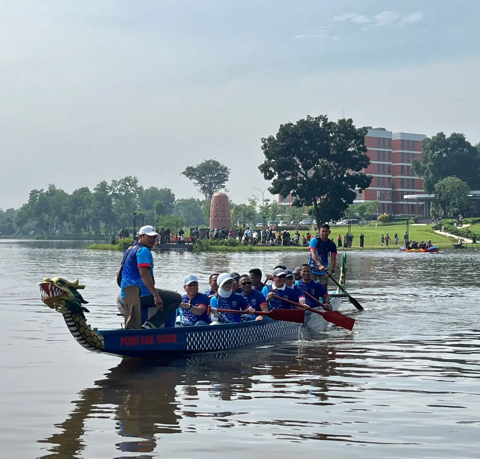 Sekda Kota Depok, Mangnguluang Mansur mendayung perahu bersama Wakil Ketua DPRD Yeti Wulandari dan jajaran Pemerintah Kota Depok saat Festival Perahu Naga di Situ Sawangan, Sabtu (13/12/25). (Foto: JD 05/Diskominfo Depok).