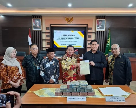 Kepala Kejasaan Negeri (Kajari) Sumedang Adi Purnama menyerahkan uang dan sertifikat hasil penyelamatan kepada  Bupati Sumedang Dony Ahmad Munir.Ist