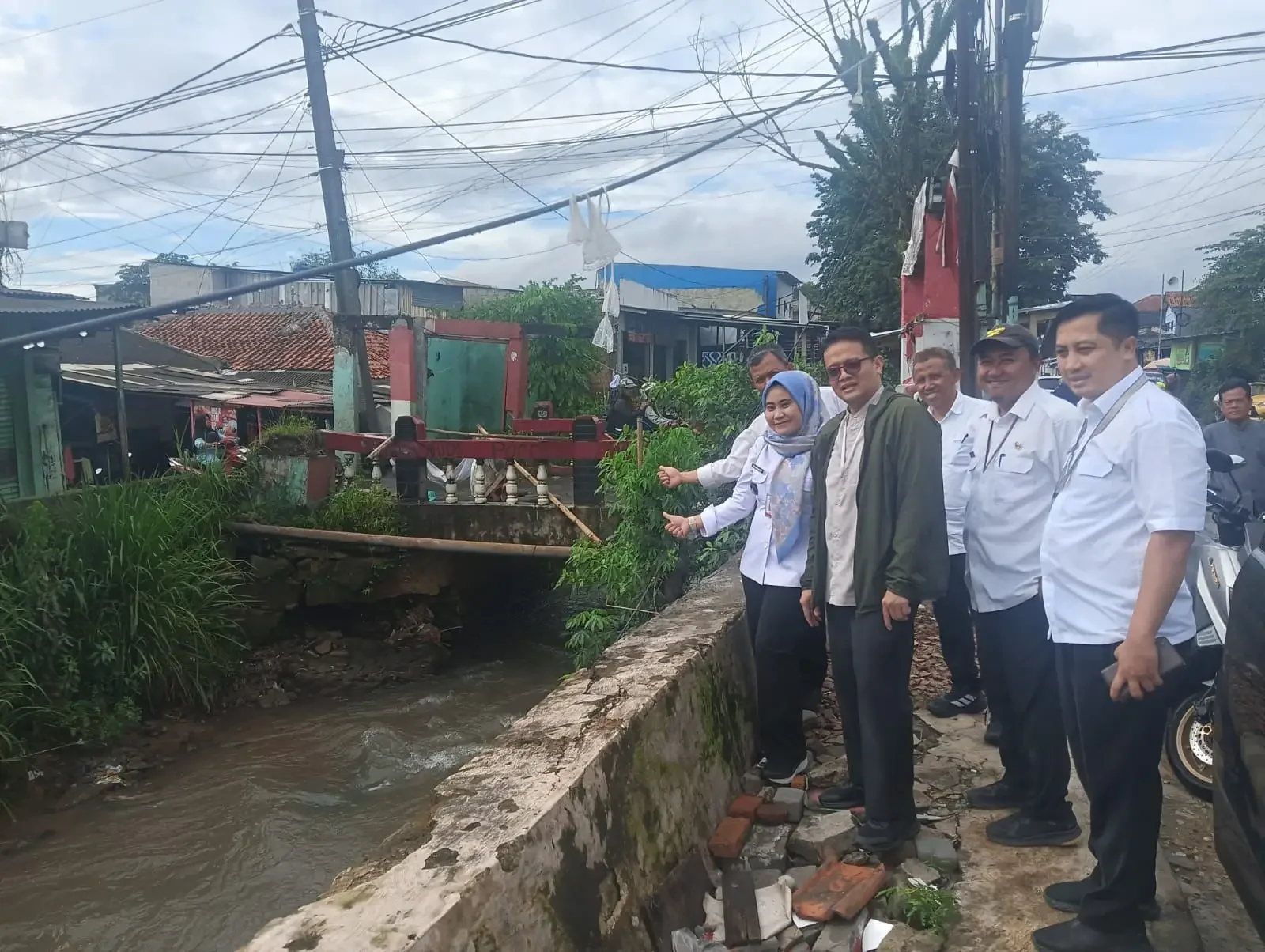 Lurah Cipayung Jaya, Susniawati (kiri) bersama jajaran Dinas PUPR dan Tim TAPD melakukan monitoring Rusaknya pondasi jembatan di Jalan Pemuda, Kampung Pulo RT 01 RW 10, Kelurahan Cipayung Jaya, Kecamatan Cipayung, pekan lalu. (Foto:Dok.Narasumber)