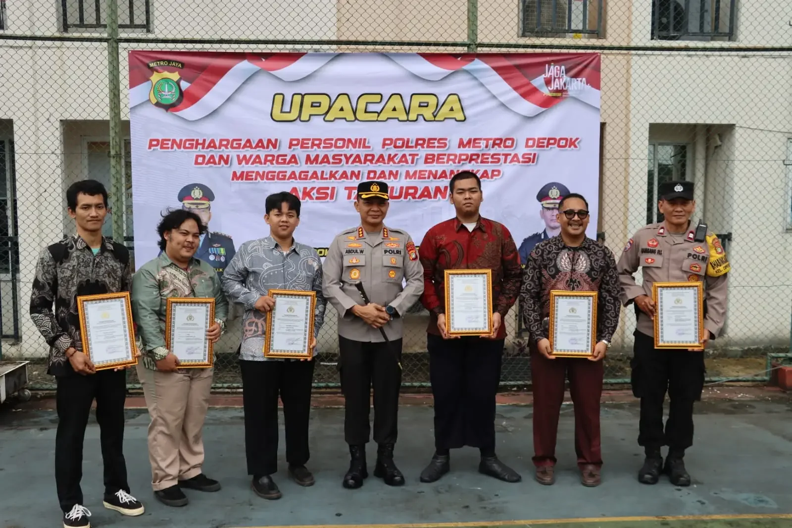 Kapolres Metro Depok, Kombes Pol Abdul Waras saat foto bersama anggota dan masyarakat mendapatkan penghargaan usai berhasil menunjukkan dedikasi, prestasi, serta integritas dalam membantu tugas kepolisian, khususnya menjaga keamanan dan ketertiban masyara