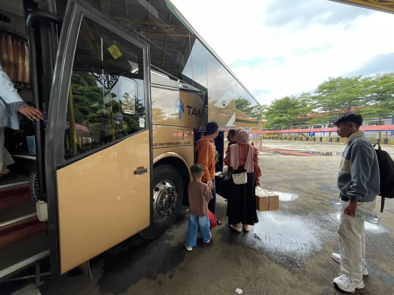 Penumpang bus di Terminal Jatijajar menaikkan barang bawaannya. (Foto: Diskominfo Depok/ Ilustrasi).
