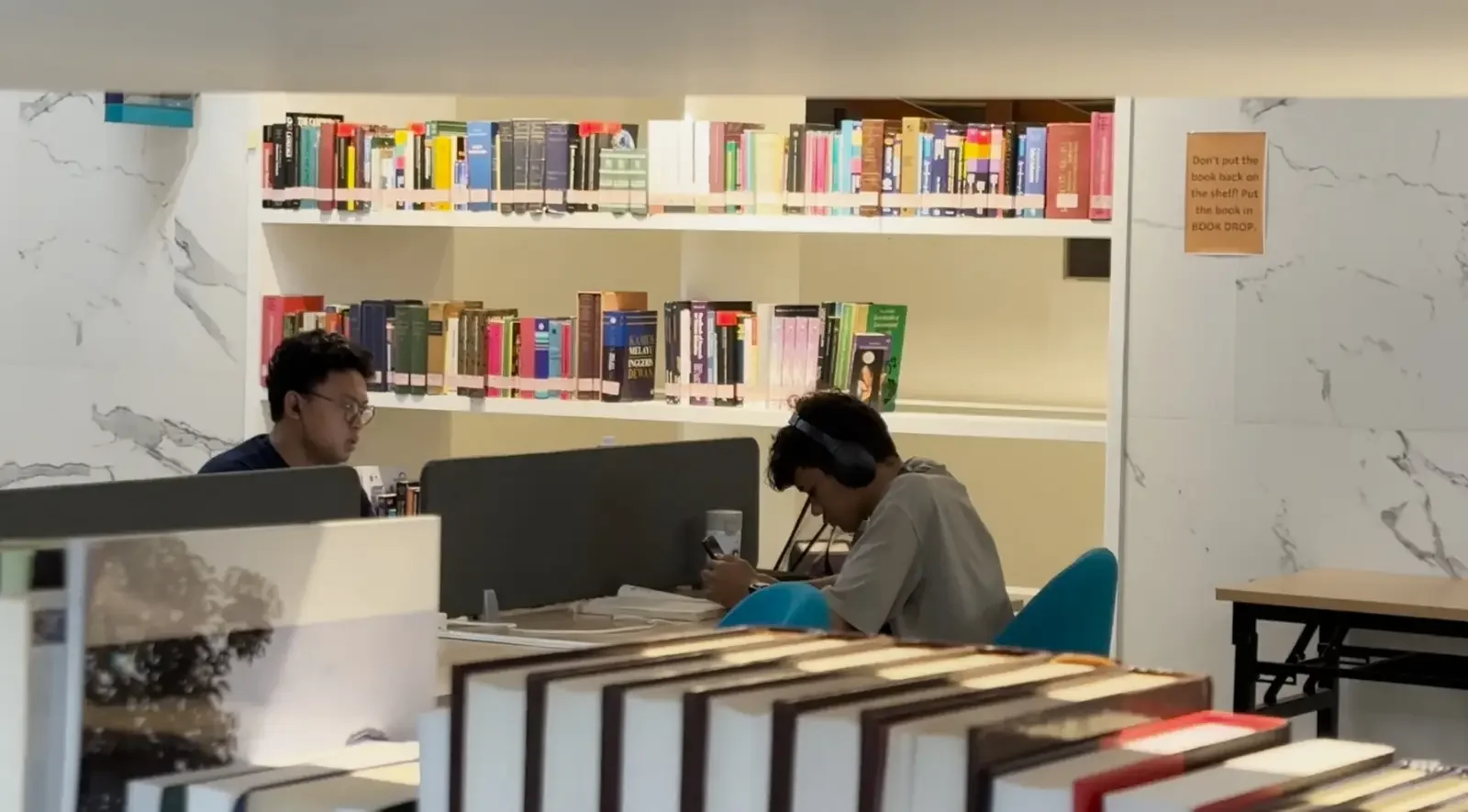 Dua anak muda Gen Z sedang asik membaca buku di Jusuf Kalla Library Universitas Islam Internasional Indonesia (UIII), belum lama ini. (Foto: Diskominfo Depok)