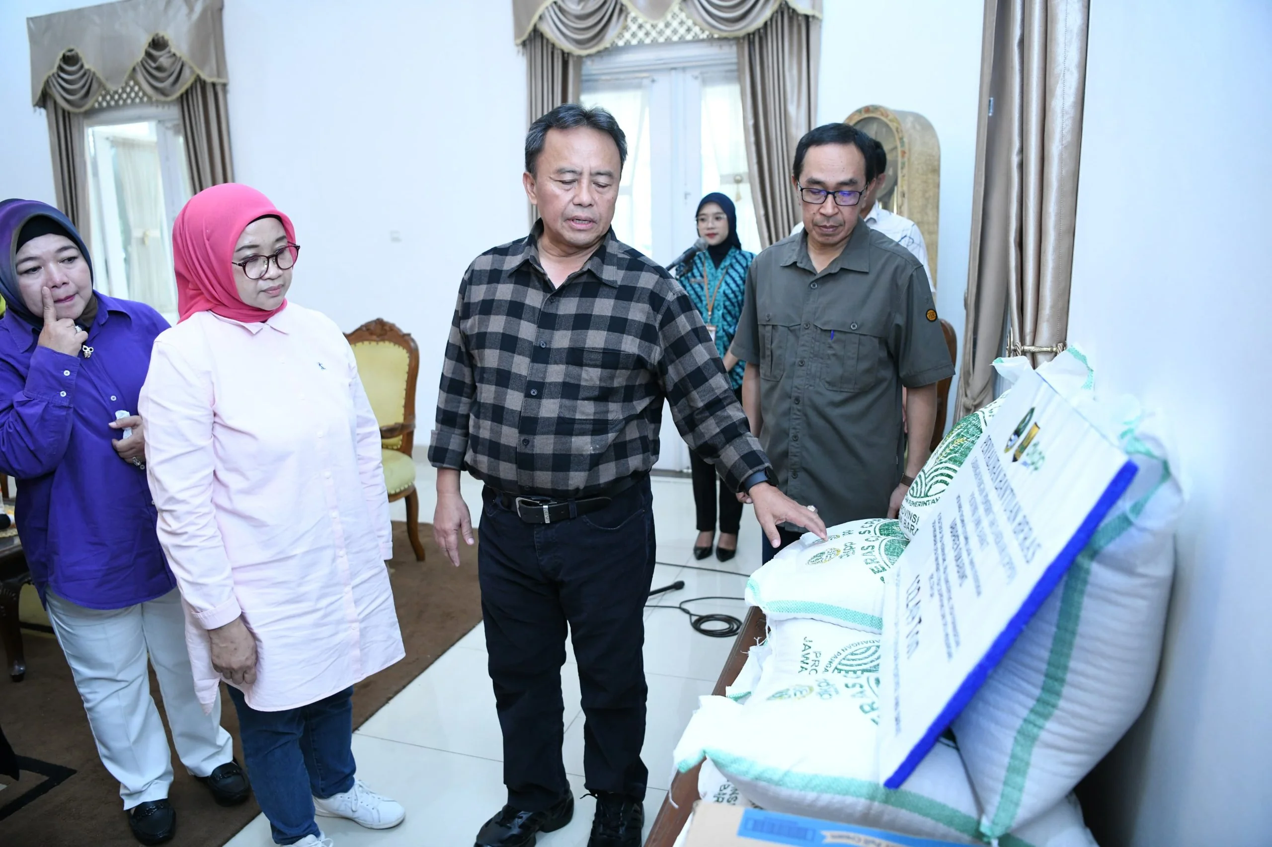 Sekda Jabar Herman Suryatman menyerahkan 
secara simbolis, beras sejumlah 122,49 ton kepada Sekda Kabupaten Sukabumi Ade Suryaman di Pendopo Kabupaten Sukabumi, Kota Sukabumi, Sabtu (28/12/2024).