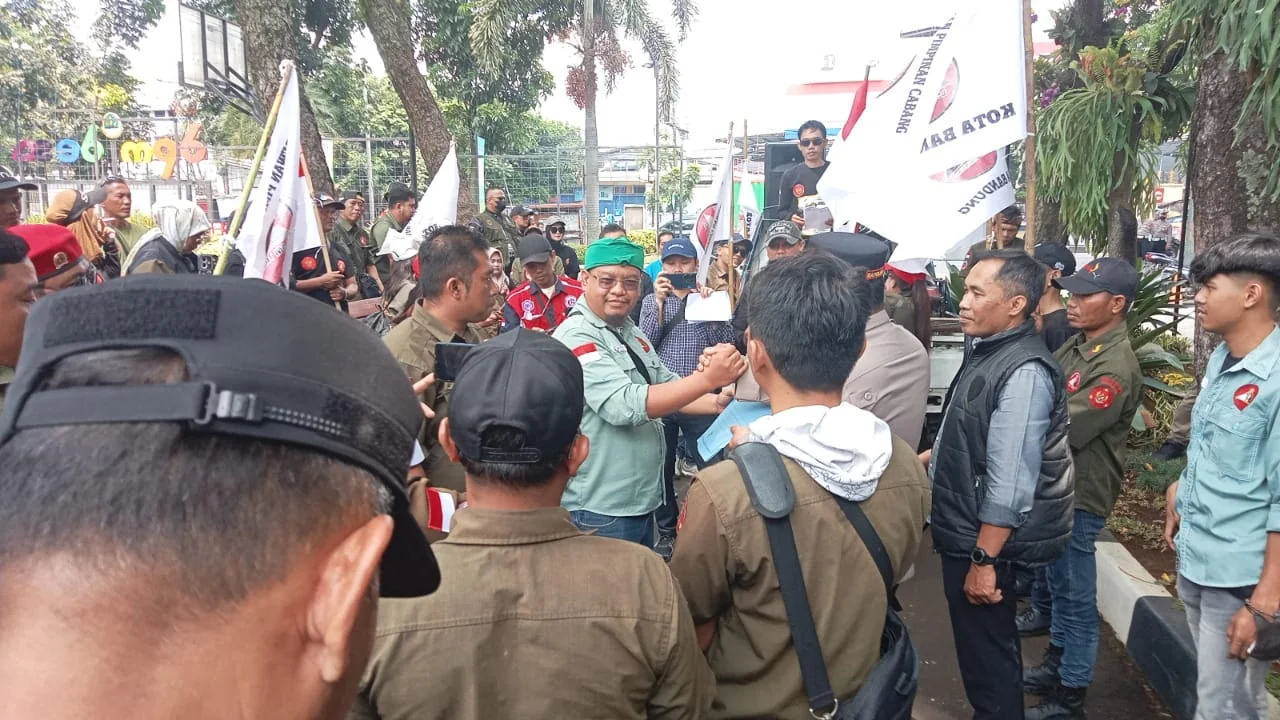 Ketua DPD LSM Trinusa Jabar, Ait M Sumarna bersalaman dengan aparat kepolisian yang telah mengawal aksi demo di Kantor DPMDP Jabar.